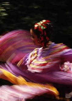 a woman in a colorful dress is dancing