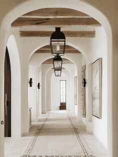 an archway leading to a hallway with lights and rugs on the floor in front of it