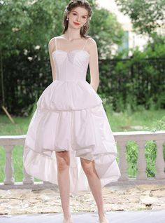 a woman in a white dress standing on a porch