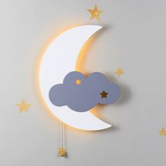 the moon and stars are hanging on the wall next to the clock, which is shaped like a cloud