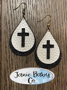 the earrings are decorated with black and white cross on it, while hanging from hooks