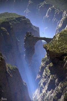 an aerial view of a canyon with a bridge in the middle