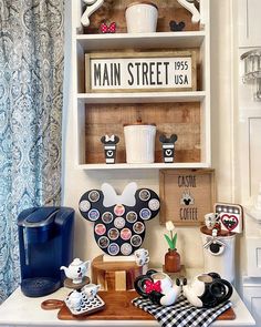 a kitchen counter topped with lots of cups and saucers next to a shelf filled with magnets