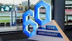 a blue and white sculpture sitting in front of a large window with the number 50 on it