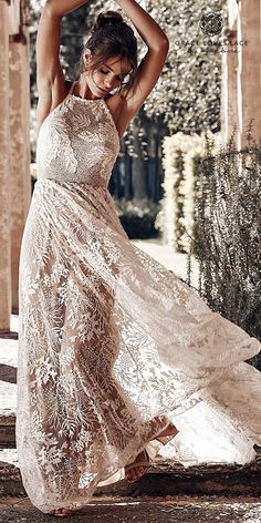 a woman in a white dress is posing for the camera with her hands on her head