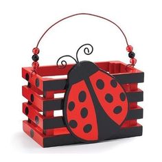 a red and black lady bug sitting on top of a wooden crate