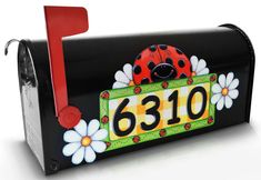 a black mailbox with a ladybug painted on the front and number plate