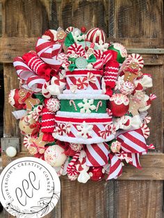 a wreath made out of candy canes and other holiday decorations on a wooden door