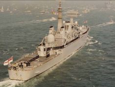 an aerial view of a large ship in the middle of the ocean with lots of other boats