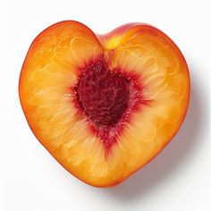 a heart shaped peach cut in half on a white background