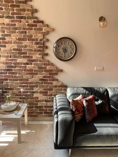 a living room with a couch, coffee table and clock on the wall above it