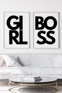 two black and white posters on the wall above a coffee table in a living room