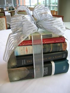 a stack of books wrapped in silver ribbon