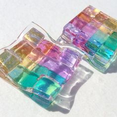 there are two small pieces of colored glass on top of each other in the shape of cubes