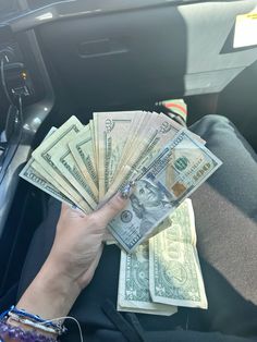 a person is holding money in their car