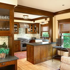 a large kitchen with wooden cabinets and an island in the middle of it, surrounded by wood flooring