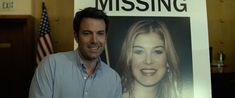 a man standing in front of a missing poster