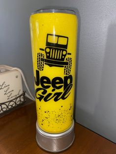 a yellow tumbler sitting on top of a wooden table