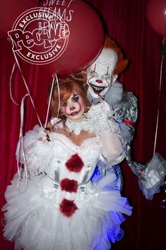 a creepy clown holding two balloons in front of a red curtain