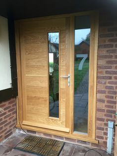 an image of a wooden door on the outside of a house with glass doors and sidelights