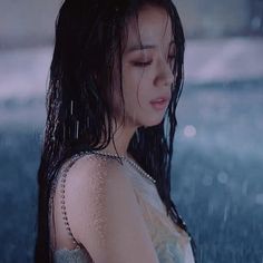 a woman standing in the rain with her eyes closed