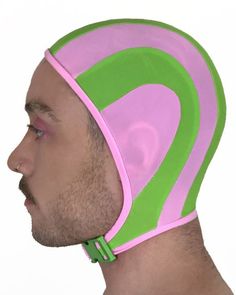 a man wearing a pink and green headgear on top of his face,