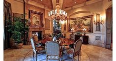 a fancy dining room with chandelier and paintings on the wall behind the table