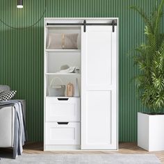 a living room with green walls and white furniture in the corner, including an open closet