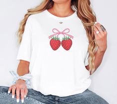 Sweeten your style with our Strawberry T-Shirt! Featuring cute strawberries and a bow, this comfy and stylish tee is perfect for casual wear and strawberry lovers. Ideal as a gift or summer wardrobe addition. Order your custom design today! Please note that the adult t-shirts are Gildan branded. Fabric: Modern, fits perfectly. 100% Soft ring-spun cotton. 90% cotton 10%polyester for Athletic Heather Size:  Please refer to Size Chart in the images for measurement of any garment Design Colour: We try our best to match colours accurately to what is seen on the screen. Colours may vary slightly in reality to what is seen on your screen due to projected light (computer light) and reflected light (when t-shirt is in hand)   Care : Warm wash, inside out. Do not tumble dry. Do not bleach. Do not dr Cute Fruit Print T-shirt, Cute Strawberry Print T-shirt As Gift, Sweet Summer Tops As Gift, Sweet Summer Tops For Gift, Sweet Summer T-shirt As Gift, Sweet T-shirt For Summer Gift, Strawberry T Shirt, Modern Fits, Fruits Decoration