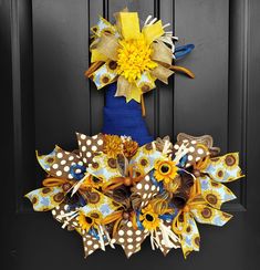 a blue vase with sunflowers and polka dots is on the front door wreath