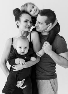 a man, woman and child are posing for a black and white photo with their arms around each other