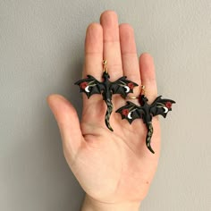 a hand holding three small black bats on it's fingers