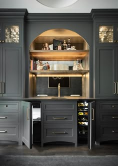 a kitchen with dark gray cabinets and gold trim on the upper half of the cupboards