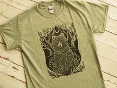 a green t - shirt with an image of a bear in the woods on it