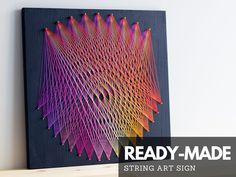 a string art artwork is displayed on a shelf with the text ready - made string art sign