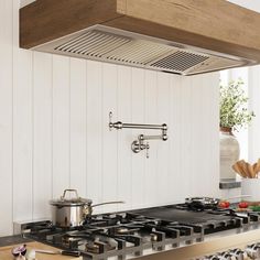 a stove top oven sitting inside of a kitchen next to a pot on a counter