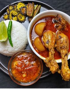 a plate with rice, meat and vegetables on it next to some dipping sauces