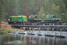 several tanks are on the bridge over water