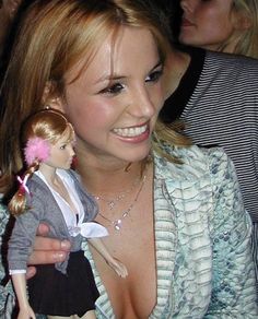 a woman holding a doll in her right hand