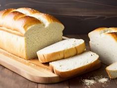 sliced loaf of bread sitting on top of a cutting board next to slices of bread