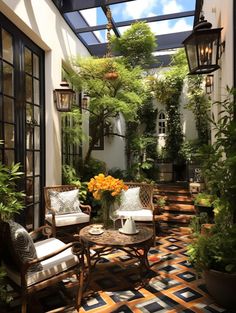 an outdoor patio with chairs, tables and potted plants on the floor in front of it