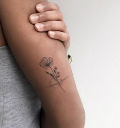 a woman's arm with a flower tattoo on the left side of her arm