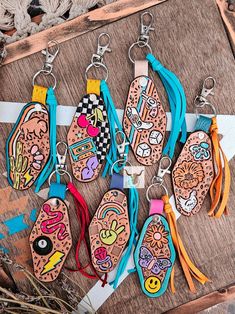 six wooden key chains with different designs on them