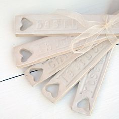 five wooden tags tied with a bow on top of a white wood flooring board