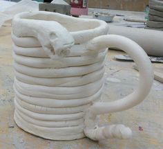 a large white vase sitting on top of a table next to a bunch of wires