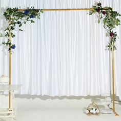 the wedding cake is on top of a stand with flowers and greenery around it