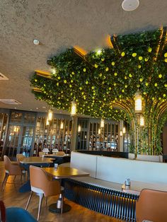 the interior of a restaurant with tables and chairs covered in lemons hanging from the ceiling