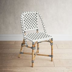 a white and black chair sitting on top of a hard wood floor next to a wall