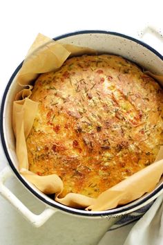 a round casserole in a white pot with some napkins on the side