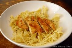 a white bowl filled with chicken and noodles